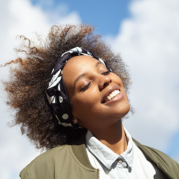 Smiling woman in headband enjoying sunlight